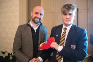 Lathallan pupil Ben Cranston receiving his red cap from Ross Campbell at Lathallan Sports Dinner 2022