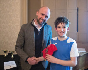 Lathallan pupil Harry Cook receiving his red cap from Ross Campbell at Lathallan Sports Dinner 2022